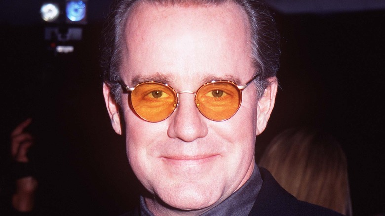 Phil Hartman posing in tinted glasses