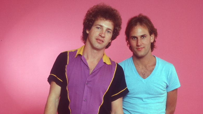 Tommy Tutone members posing together in front of pink background