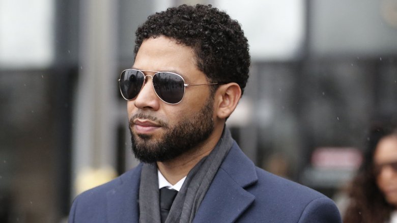 Jussie Smollett walking outside a courthouse, wearing sunglasses