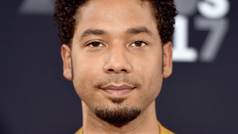 Jussie Smollett posing at an event with a neutral expression