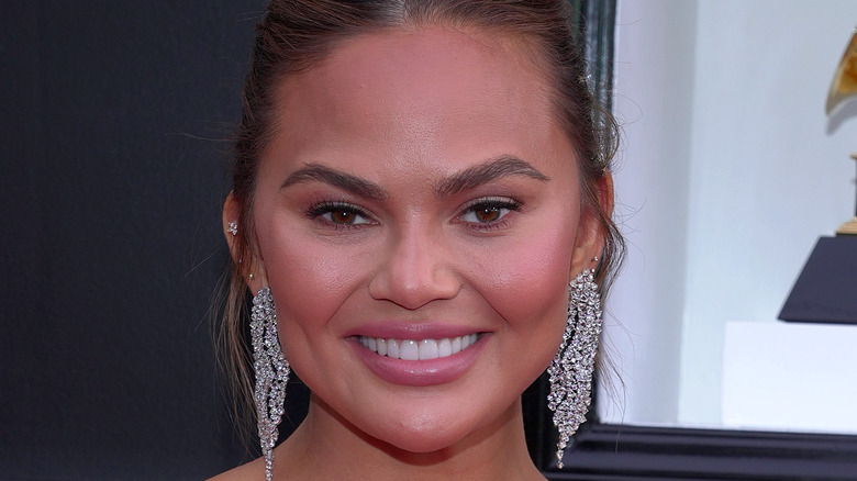 Chrissy Teigen with her hair up and massive sparkly earrings