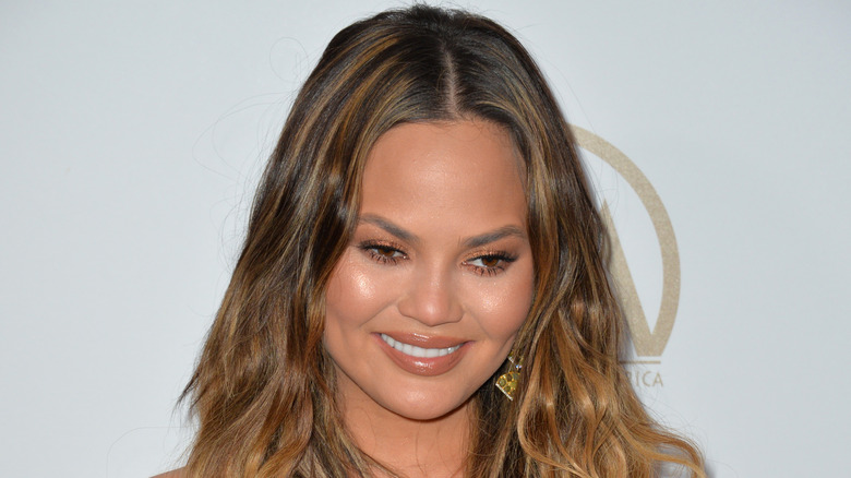 Chrissy Teigen looking down and smiling