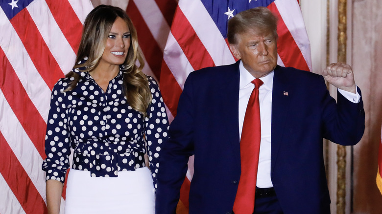 Melania Trump looks as Donald Trump pumps his fist