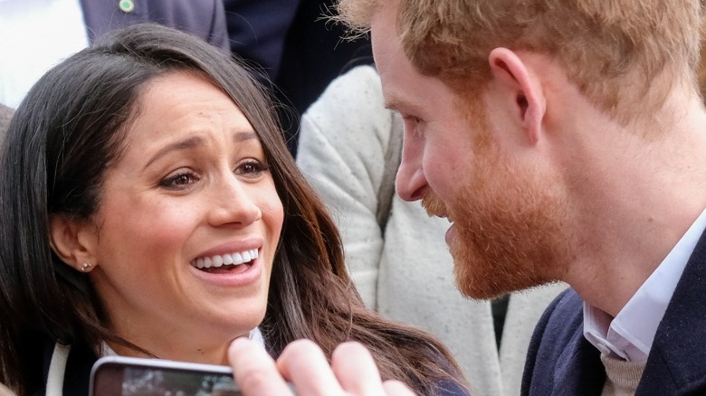 Meghan Markle and Prince Harry smiling at each other