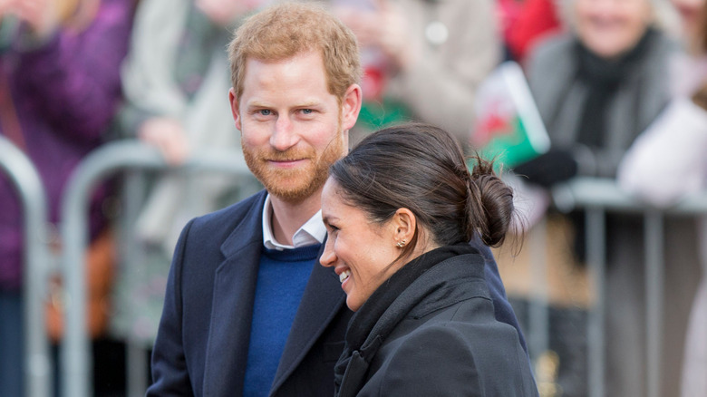 Prince Harry and Meghan Markle smiling at an event