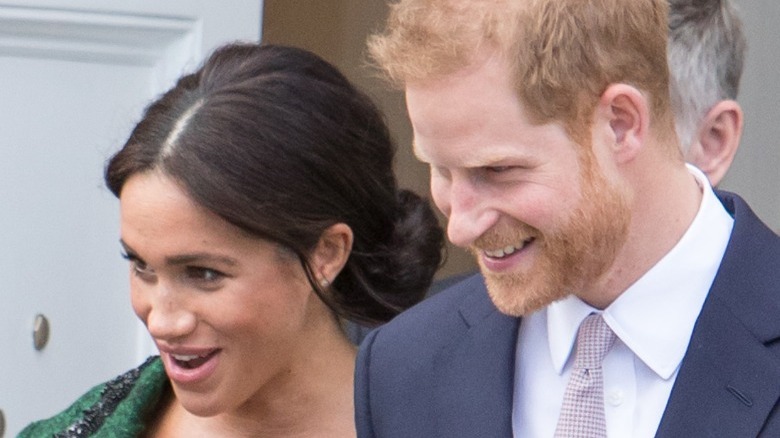 Meghan Markle and Prince Harry smiling at the crowd