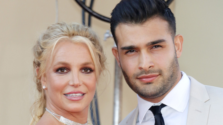 Britney spears and sam asghari smiling on red carpet