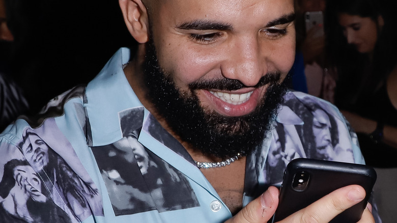 Drake smiling at his phone