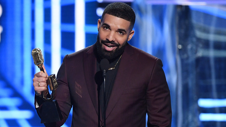 Drake holds an award