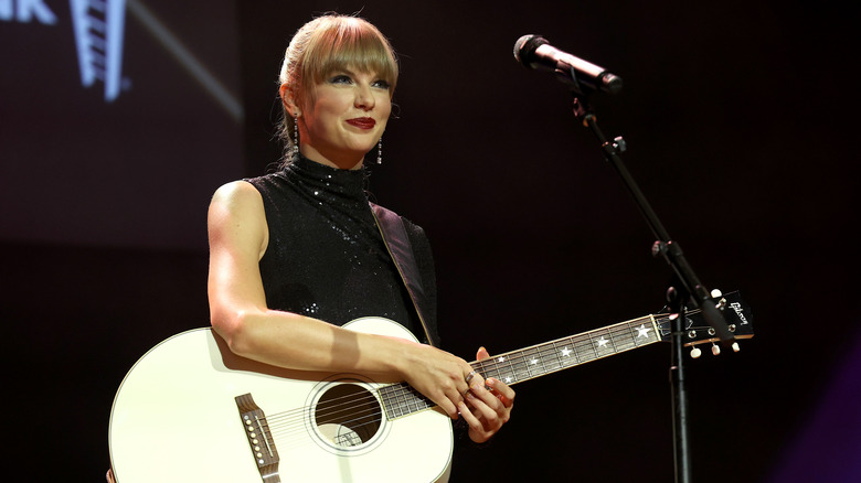 Taylor Swift holds guitar 