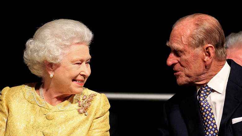 Queen Elizabeth smiles at Prince Philip during a conversation