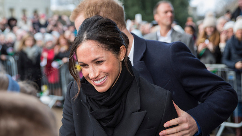 Meghan Markle and Prince Harry walking in crowd