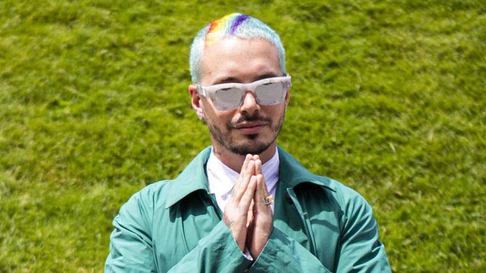 J Balvin standing in front of greenery