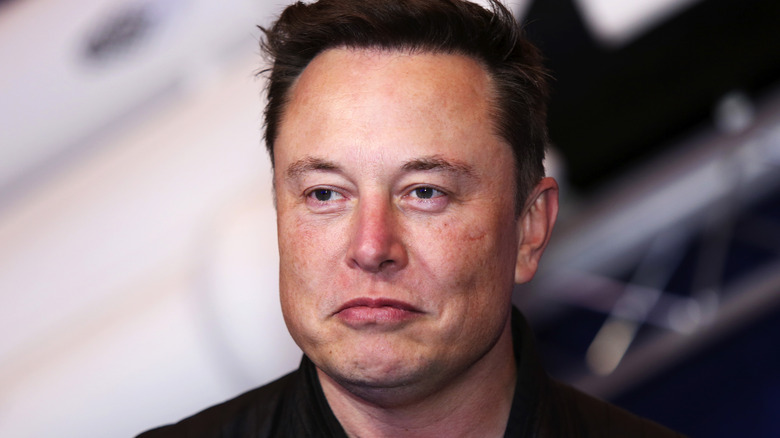 Elon Musk looking up and to the side with slight smirk