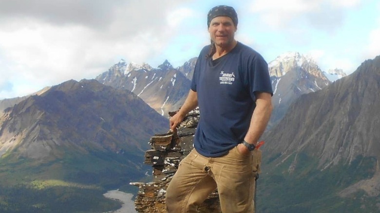 Roland Welker smiling on a mountain cliff