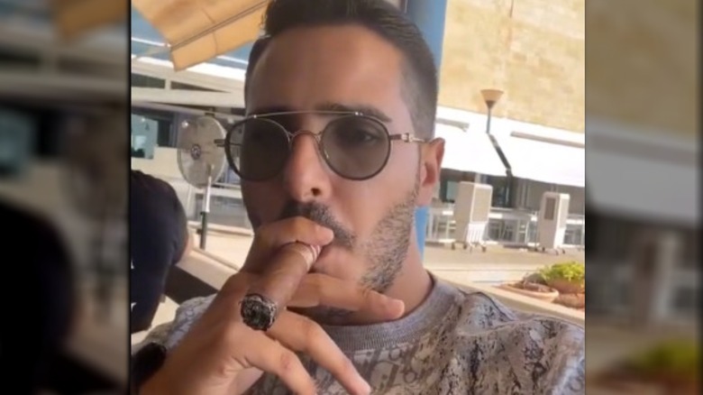 The Tinder Swindler smoking a cigar