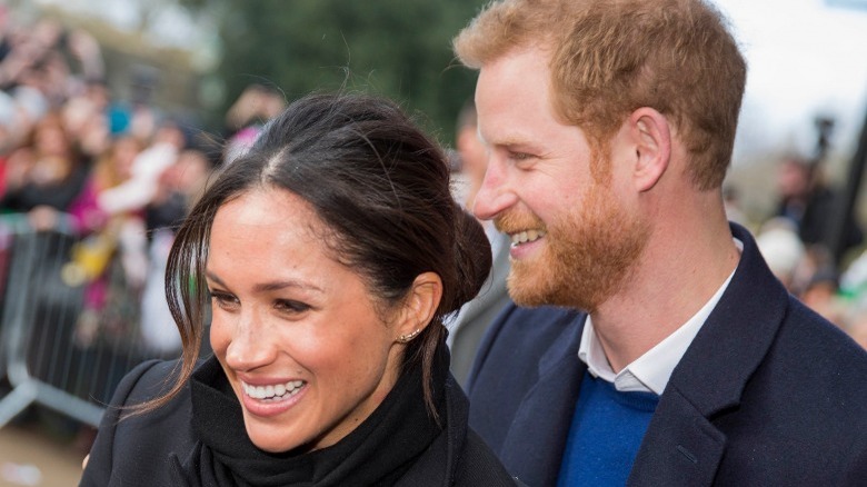 Prince Harry and Meghan Markle smiling at an event