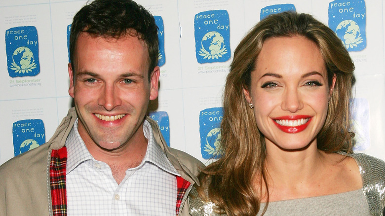 Angelina Jolie and Jonny Lee Miller smiling on the red carpet