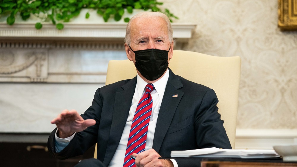 Joe Biden speaking in his office while wearing a mask