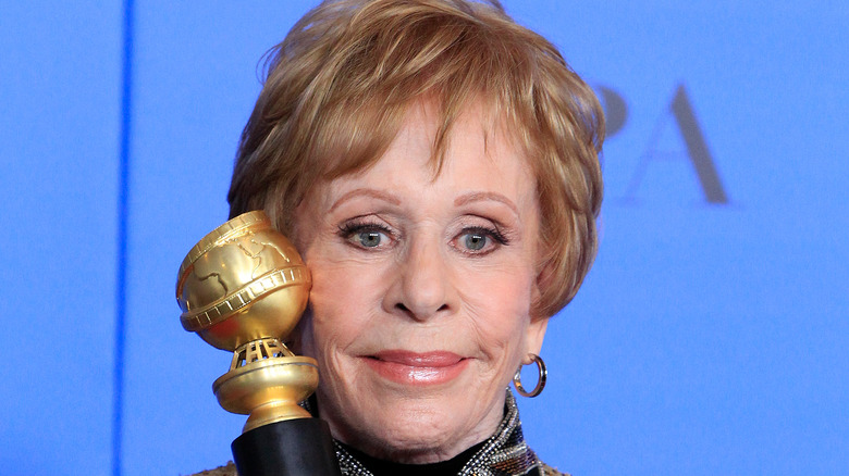 Carol Burnett holding a Golden Globe