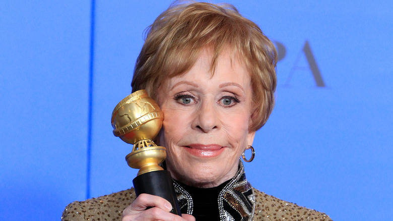 Carol Burnett smiling and holding award at the Golden Globes