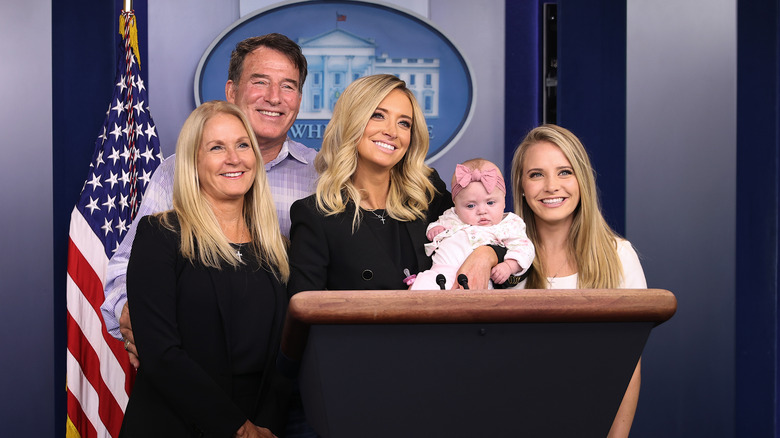 2020 photo of then-White House Press Secretary Kayleigh McEnany with five-month-old daughter Blake Gilmartin, parents Mike and Leanne McEnany and sister Ryann McEnany at the podium in the Brady Press Briefing Room