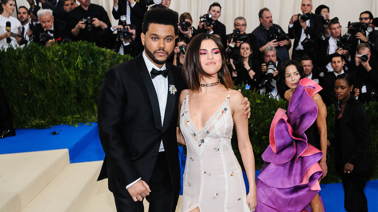 The Weeknd and Selena Gomez pose on stairs