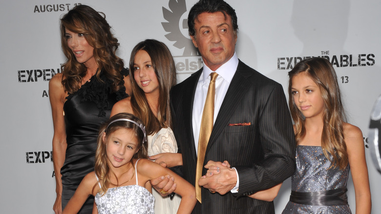 Sylvester Stallone posing with his wife and daughters