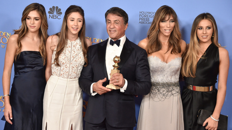 Sylvester Stallone posing with his wife and daughters