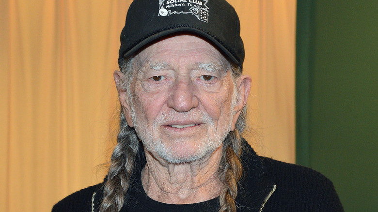 Willie Nelson holding his 2012 autobiography.