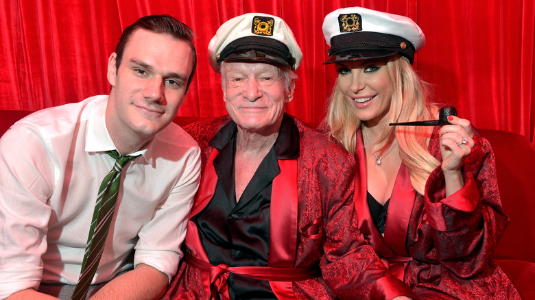 Hugh Hefner smiling with Cooper and Crystal Harris