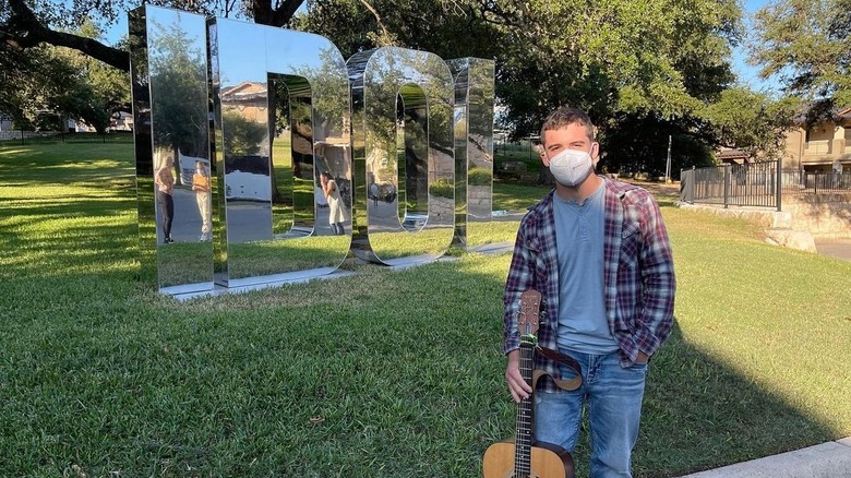 Noah Thompson posing in front of Idol sign