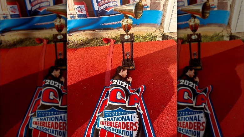 Jordon Hudson laying next to trophy