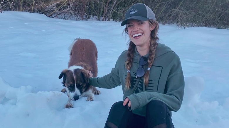 Carly Haack sitting in snow with dog