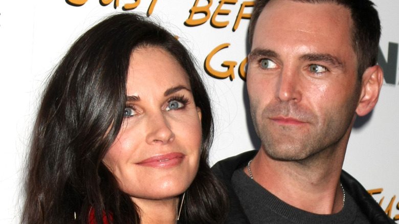 Courteney Cox looks upward while Johnny McDaid gazes back