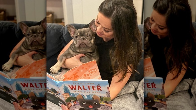 Eva Pilgrim posing with her book and dog