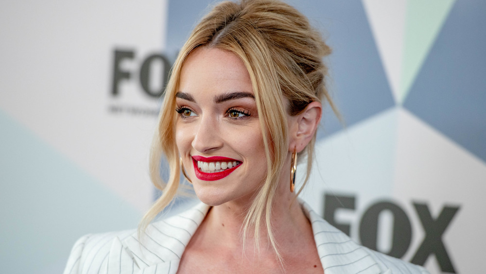 Brianne Howey smiles while posing at an event