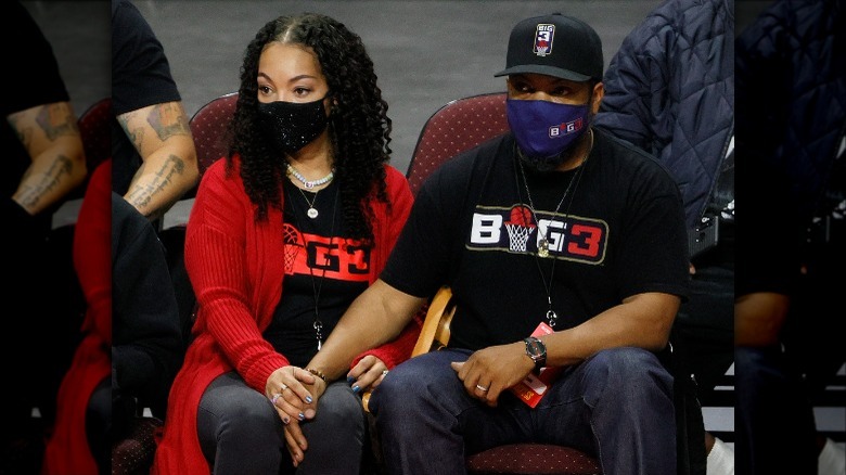 Ice Cube holds hands with Kimberly Woodruff at basketball game