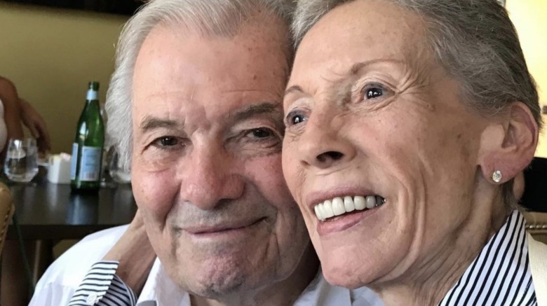 Jacques Pépin smiling, looking at camera; Gloria Pépin, laughing, not looking at camera, arms wrapped around her husband