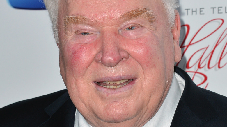 John Madden poses in a suit