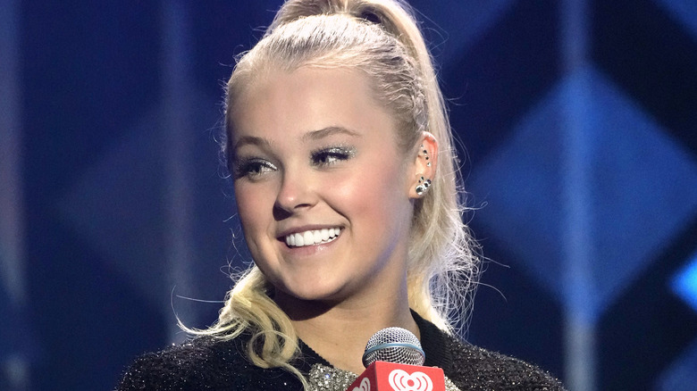 Jojo Siwa holding a microphone