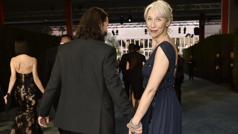 Keanu Reeves and Alexandra Grant hold hands