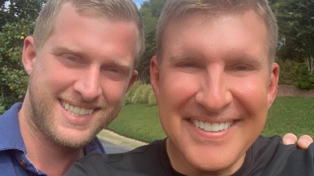 Kyle Chrisley and Todd Chrisley smiling and hugging 