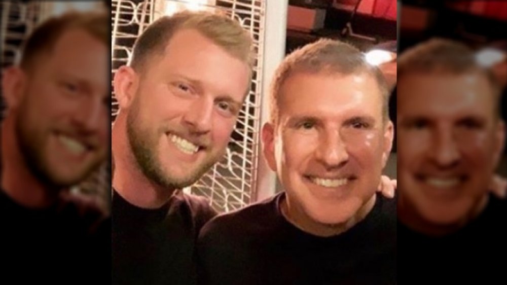 Kyle Chrisley and Todd Chrisley smiling and hugging 