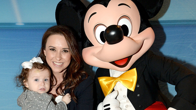 Lacey Chabert and her daughter posing with Mickey Mouse