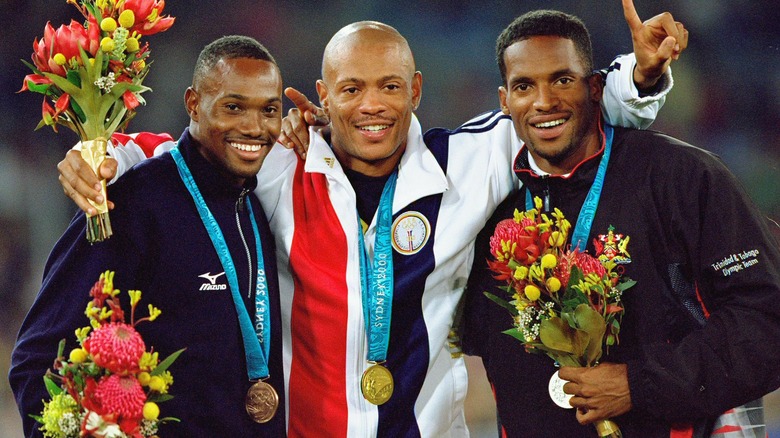 Obadele Thompson, Maurie Greene, and Ato Boldon wearing medals