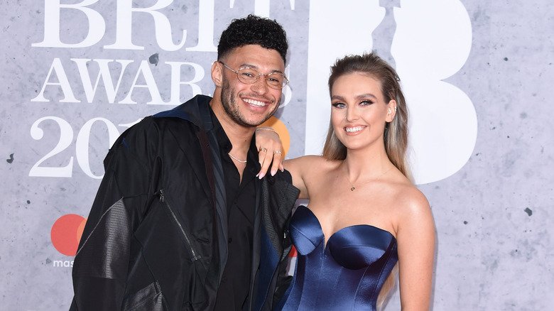 Alex Oxlade-Chamberlain and Perrie Edwards smile at the BRIT Awards