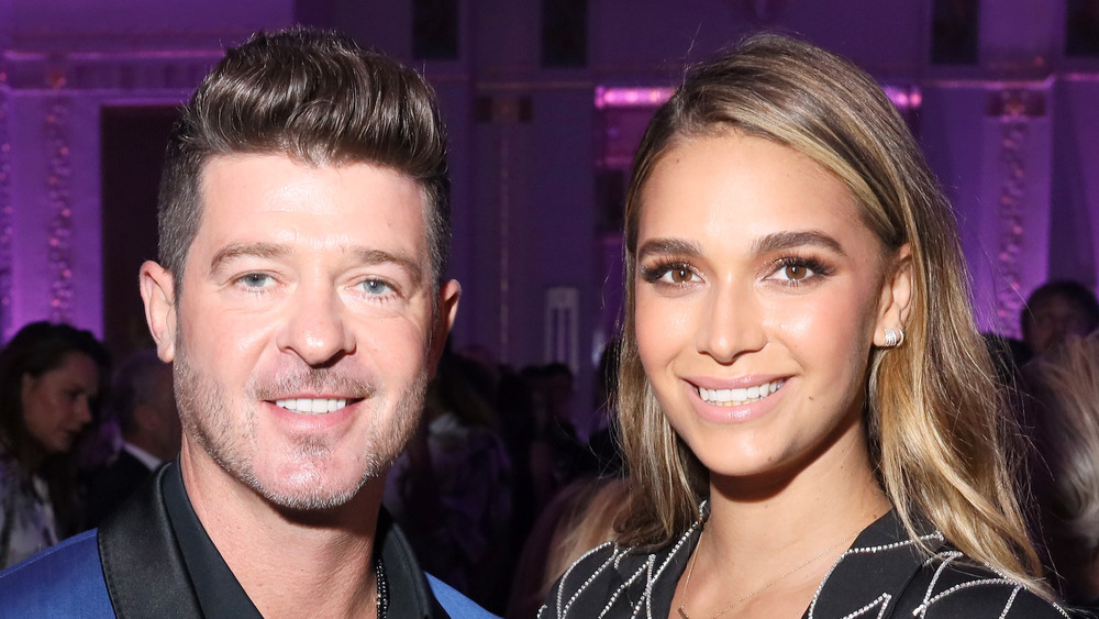 Robin Thicke and April Love Geary posing together at an event