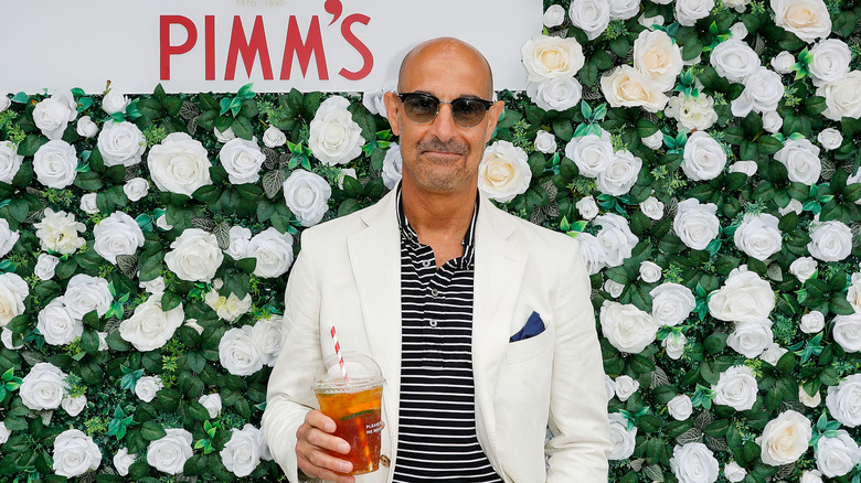 Stanley Tucci, drink in hand, at an event