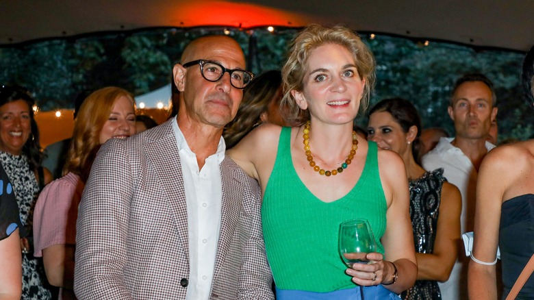 Felicity Blunt and Stanley Tucci acting casual at a party.